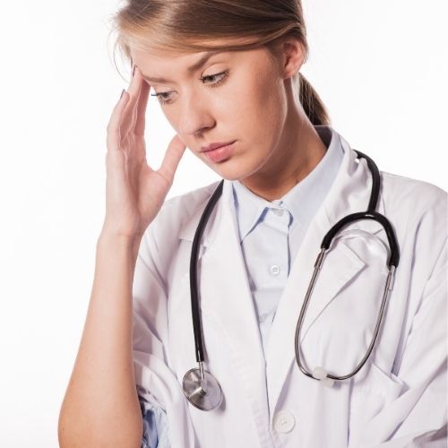 Enfermera con migraña por exceso de trabajo y estrés.