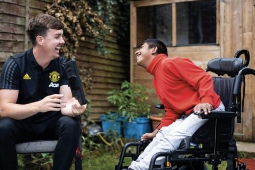 El personal de la Fundación Manchester United visita a un joven aficionado.
